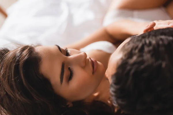 Вид сверху на сексуальную женщину, трогающую парня в спальне — стоковое фото