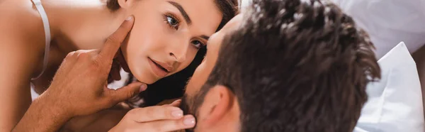 Panorâmica tiro de mulher sensual tocando namorado na cama — Fotografia de Stock