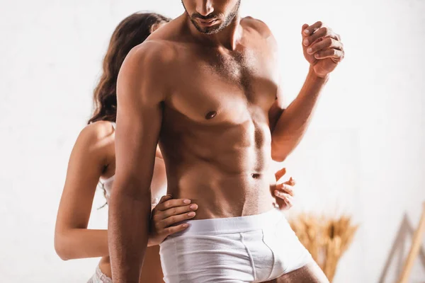 Сексуальная женщина трогает мускулистого мужчину в трусах дома — стоковое фото