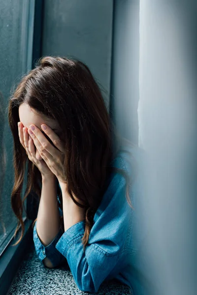 Foyer sélectif de femme brune frustrée couvrant le visage à la maison — Photo de stock