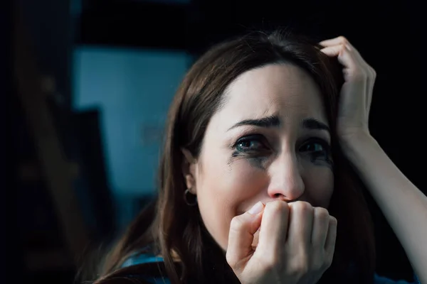 Brünette Frau mit geflossener Wimperntusche weint und schaut zu Hause weg — Stockfoto