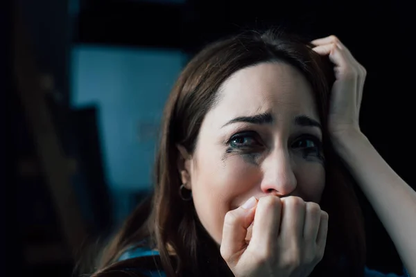 Brunette woman with flowed mascara crying and looking away at home — Stock Photo