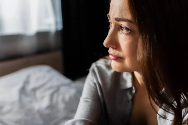 Unzufriedene brünette Frau schaut zu Hause weg — Stockfoto