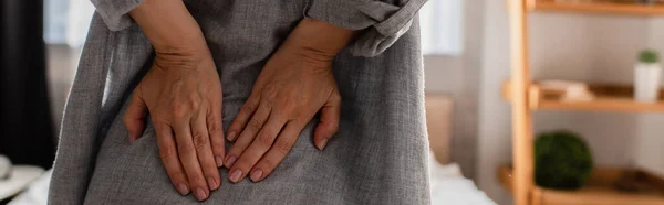 Panoramic crop of woman suffering from back pain at home — Stock Photo