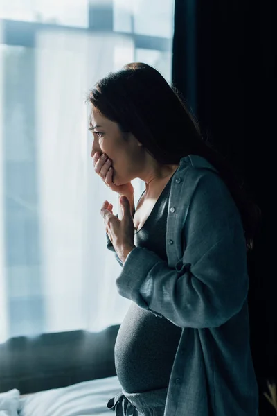Bruna donna incinta che copre la bocca mentre ha nausea a casa — Foto stock