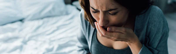 Panoramic crop of woman covering mouth while having nausea at home — Stock Photo