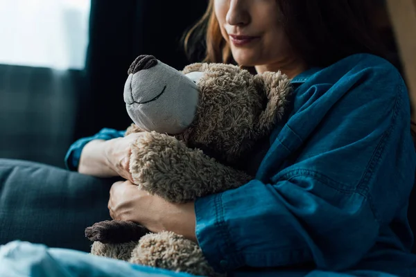 Cropped view of depressed brunette woman holding teddy bear — Stock Photo