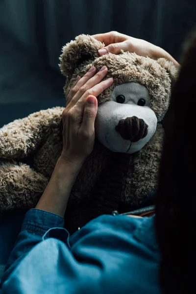 Enfoque selectivo de mujer morena sosteniendo oso de peluche - foto de stock