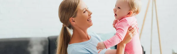 Panoramaaufnahme einer Frau, die ihre kleine Tochter zu Hause hält — Stockfoto