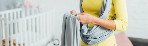 Panoramic shot of woman carrying baby sling at home — Stock Photo