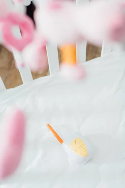Selective focus of baby monitor in crib with soft toys — Stock Photo