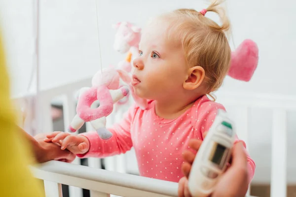 Säugling in Krippe nahe Mutter mit elektronischem Inhalator im Fokus — Stockfoto