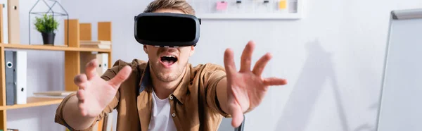 Image horizontale de l'homme d'affaires excité gestuelle tout en utilisant vr casque dans le bureau — Photo de stock