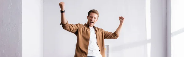 Panoramic shot of businessman showing yes gesture in office — Stock Photo