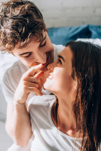 Young man looking at girlfriend and pointing with finger — Stock Photo