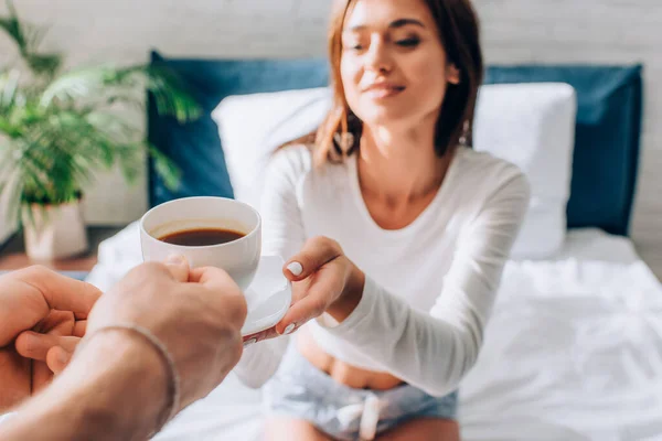 Foco seletivo do homem dando xícara de café para namorada — Fotografia de Stock