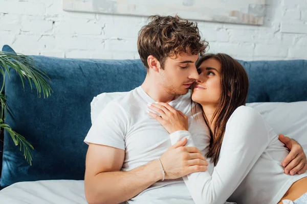 Jovem casal deitado na cama e olhando uns para os outros — Fotografia de Stock