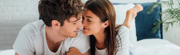 Plan panoramique de jeunes couples couchés sur le lit le matin — Photo de stock