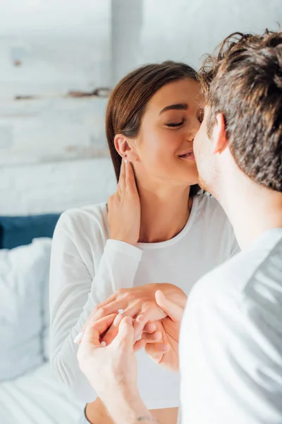 Enfoque selectivo de pareja joven besándose durante el matrimonio proponen en dormitorio - foto de stock