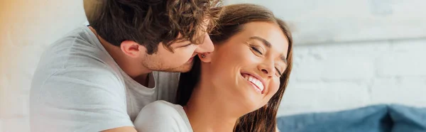 Cosecha horizontal del hombre mirando a su novia con los ojos cerrados en casa - foto de stock