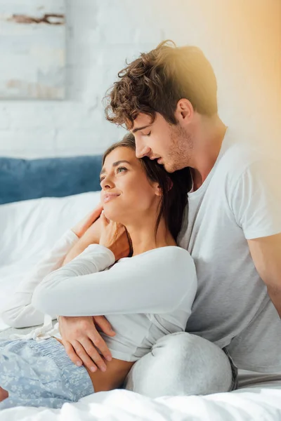 Selective focus of young woman touching boyfriend on bed — Stock Photo