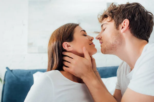 Jovem homem tocando e beijando namorada em casa — Fotografia de Stock