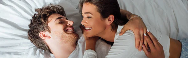 Horizontal crop of couple embracing on bed during morning — Stock Photo