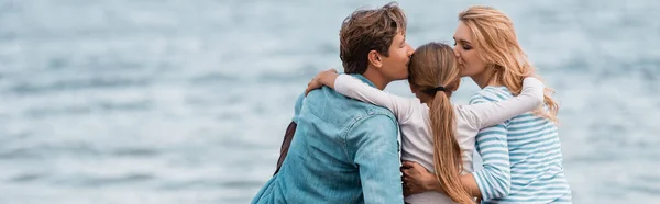 Horizontal crop of parents kissing daughter near sea — Stock Photo