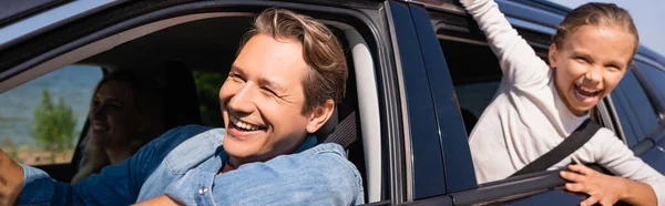 Panoramic concept of man driving car near family during weekend — Stock Photo