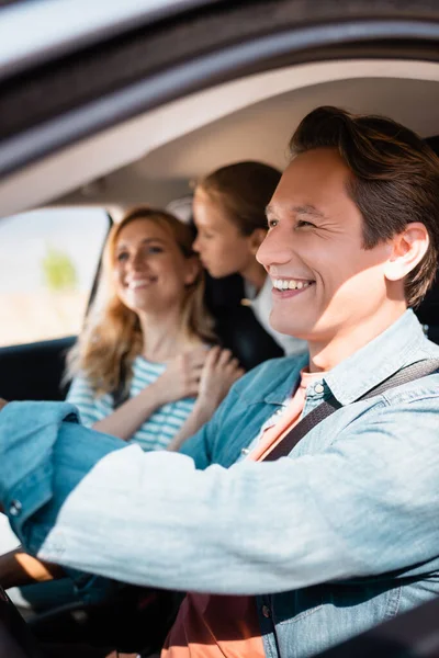 Selective focus of man driving car during vacation with family — Stock Photo