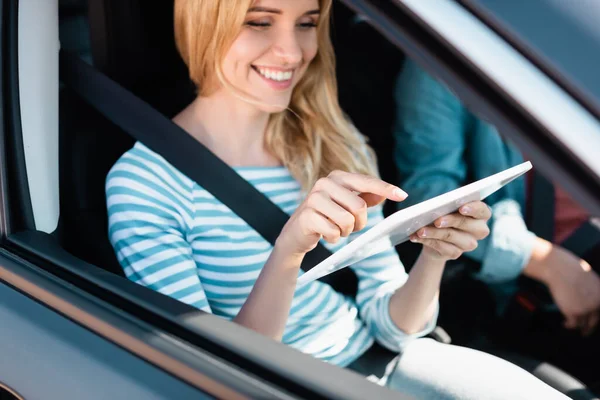Selektiver Fokus der Frau, die mit dem Finger auf digitales Tablet neben Ehemann im Auto zeigt — Stockfoto
