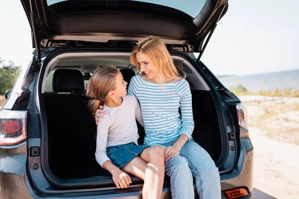 Femme étreignant et regardant fille pendant le week-end en voiture — Photo de stock