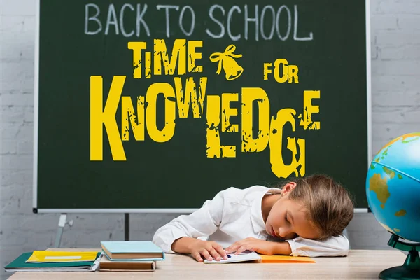 Exhausted schoolgirl sleeping at desk near globe and chalkboard with back to school and time for knowledge lettering — Stock Photo