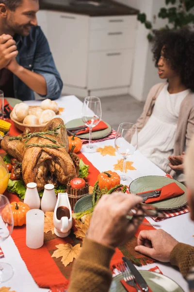 Foco seletivo do homem conversando com a filha afro-americana durante o jantar de ação de graças com a família — Fotografia de Stock