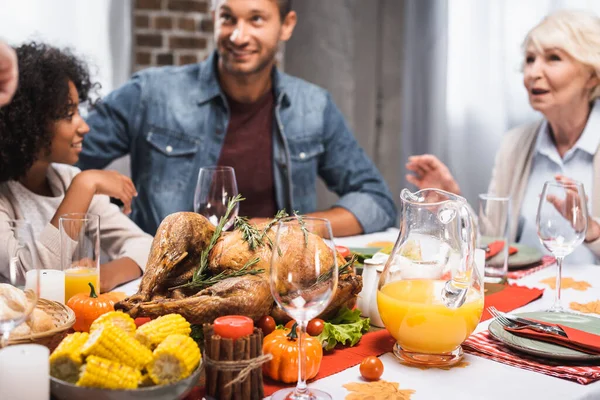 Focus selettivo della famiglia multiculturale che celebra il giorno del Ringraziamento a tavola servito con una deliziosa cena — Foto stock