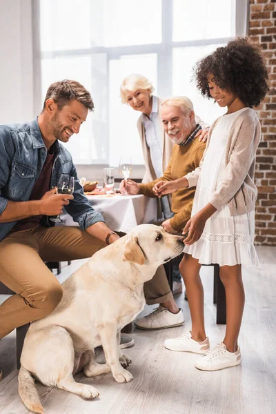 Selective focus of african american girl and golden retriever near family celebrating thanksgiving day — Stock Photo