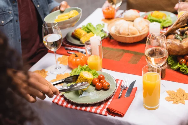 Cropped view of man taking corn during thanksgiving dinner — Stock Photo