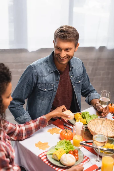Selective focus of man looking at african american girl taking bun — Stock Photo