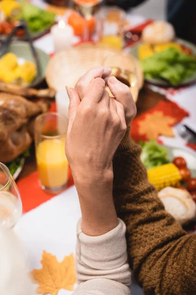 Cropped view of senior couple holding hands on thanksgiving — Stock Photo