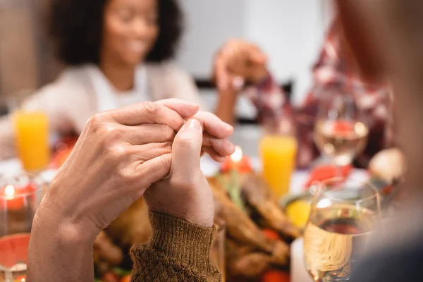 Selective focus of senior man and woman holding hands on thanksgiving — Stock Photo