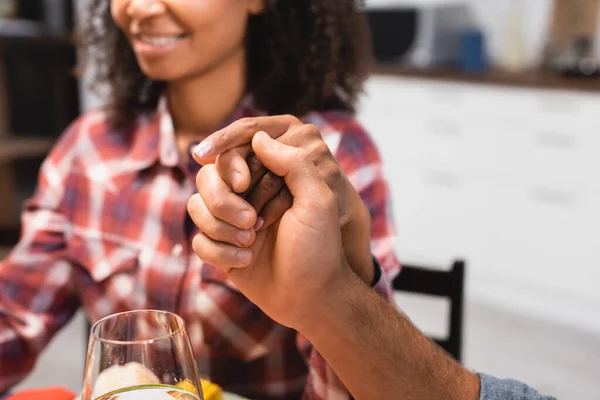Обрезанный вид на мужчину и африканскую американскую девушку, держащихся за руки на День Благодарения — стоковое фото