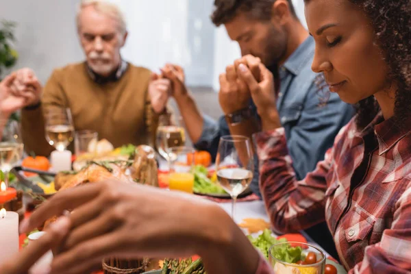 Foyer sélectif famille multiculturelle avec les yeux fermés tenant la main sur thanksgiving — Photo de stock