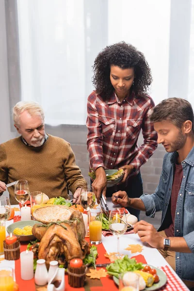 Africano americano mulher servindo comida no prato do homem em ação de graças — Fotografia de Stock