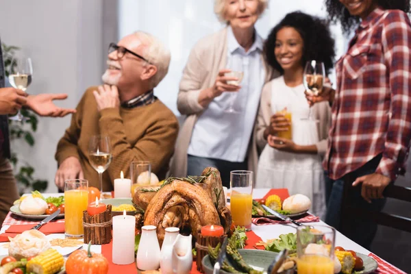 Focus selettivo della famiglia multietnica che celebra il Ringraziamento a tavola con cena festiva — Foto stock