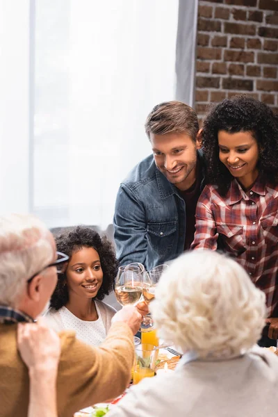 Selektiver Schwerpunkt multiethnischer Familienanstoßen mit Wein beim Erntedank — Stockfoto