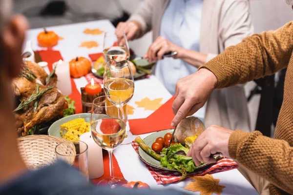 Selektiver Fokus des Seniors beim Salatschneiden im Familienkreis beim Erntedank-Dinner — Stockfoto