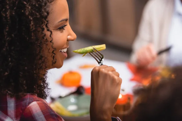 Foco seletivo da mulher afro-americana comendo espargos durante o jantar de ação de graças — Fotografia de Stock