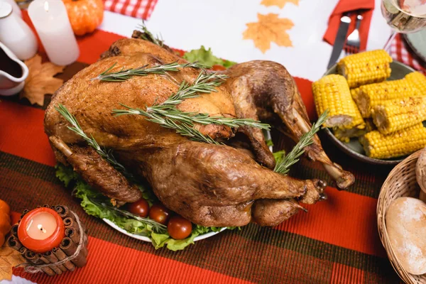 Foco seletivo de peru saboroso na mesa perto de velas e milho — Fotografia de Stock