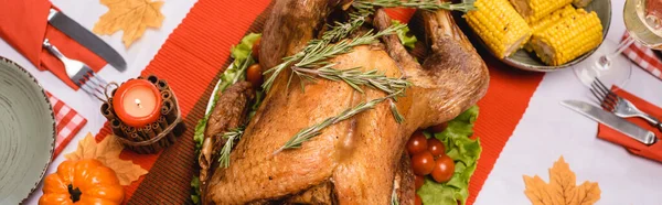 Foto panorámica de pavo de acción de gracias cerca de vela y calabaza en la mesa - foto de stock