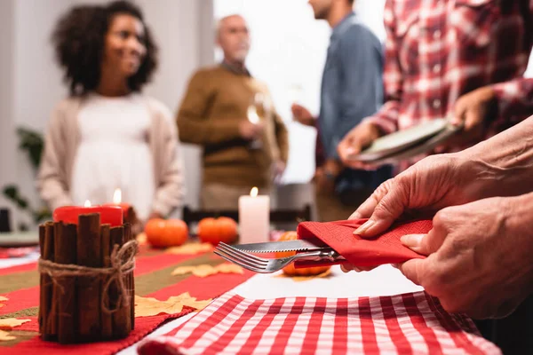 Selektiver Fokus der Seniorin, die während des Erntedankfestes Besteck in der Hand hält — Stockfoto